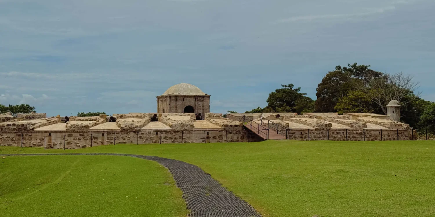Path across a green lawn leading to the entrance gate and domed powder magazine of Fort San Lorenzo -- Portobelo Panama