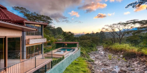 Riverside boutique hotel with an infinity pool and rocky riverbank at sunset at The Inn at Palo Alto in Boquete Panama -- Boquete Panama