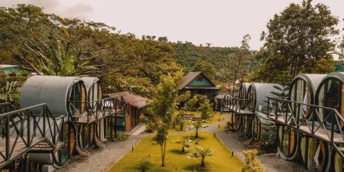 Unique barrel-shaped guest rooms lining a garden pathway surrounded by tropical trees at ONDA Boquete in Panama -- Boquete Panama